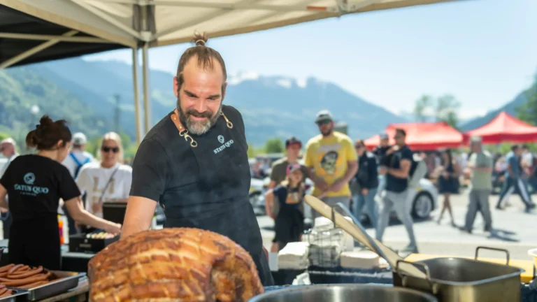 Koch schneidet Spanferkel am Grill